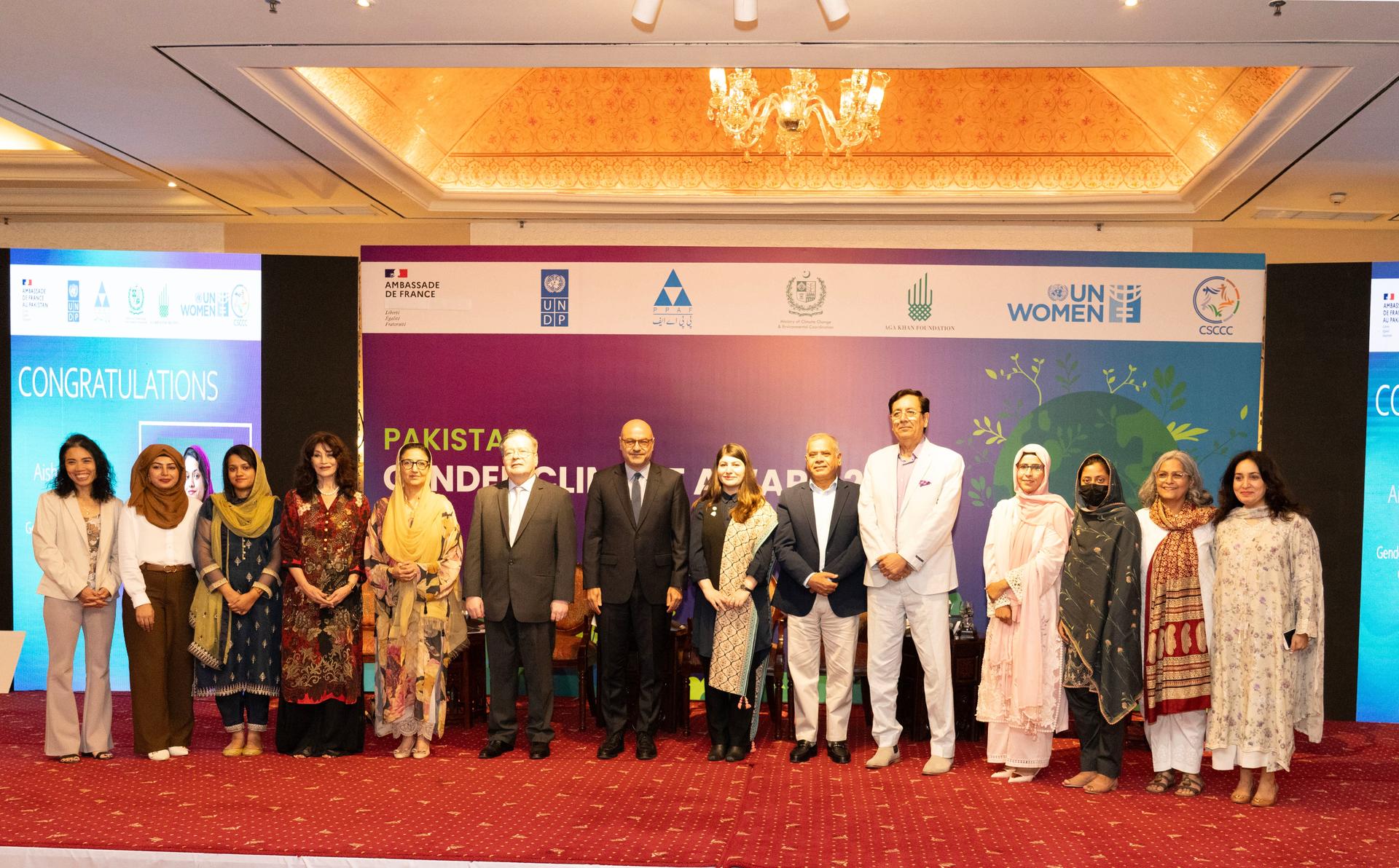 A group of professionals standing together on stage at a conference, smiling.