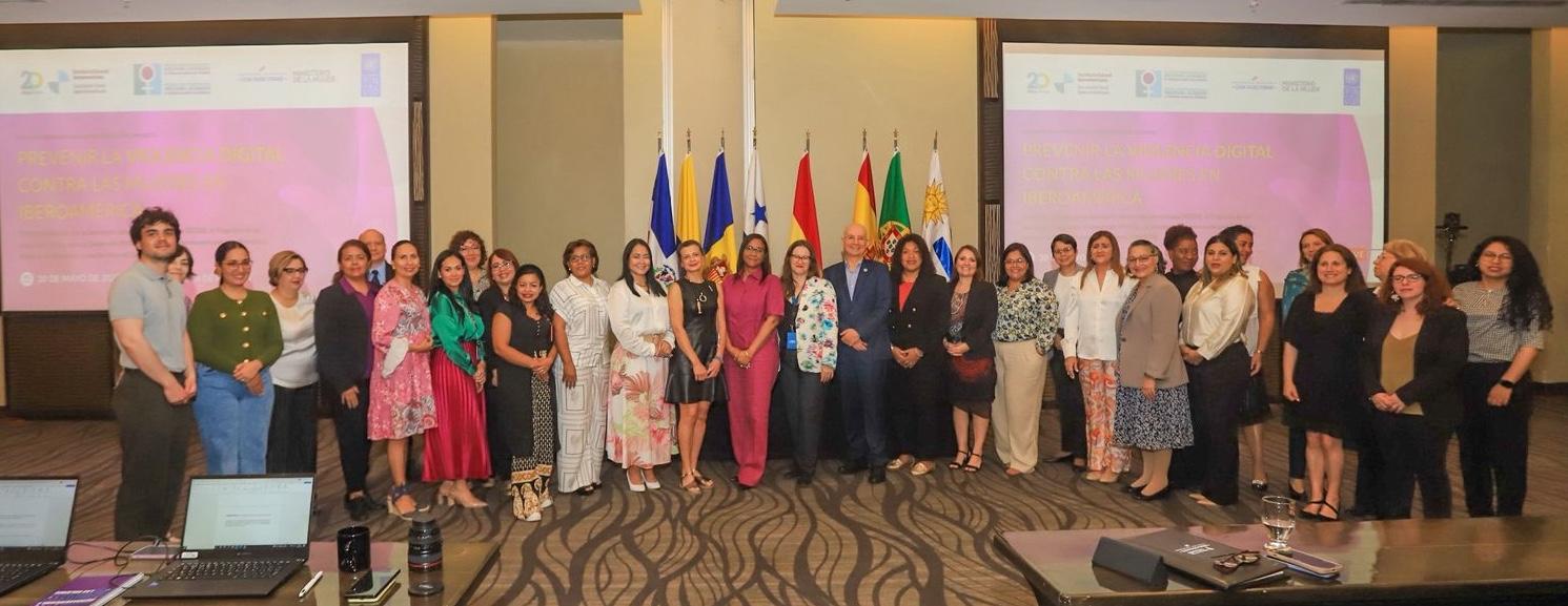 Group photo of diverse individuals standing together in a conference setting.
