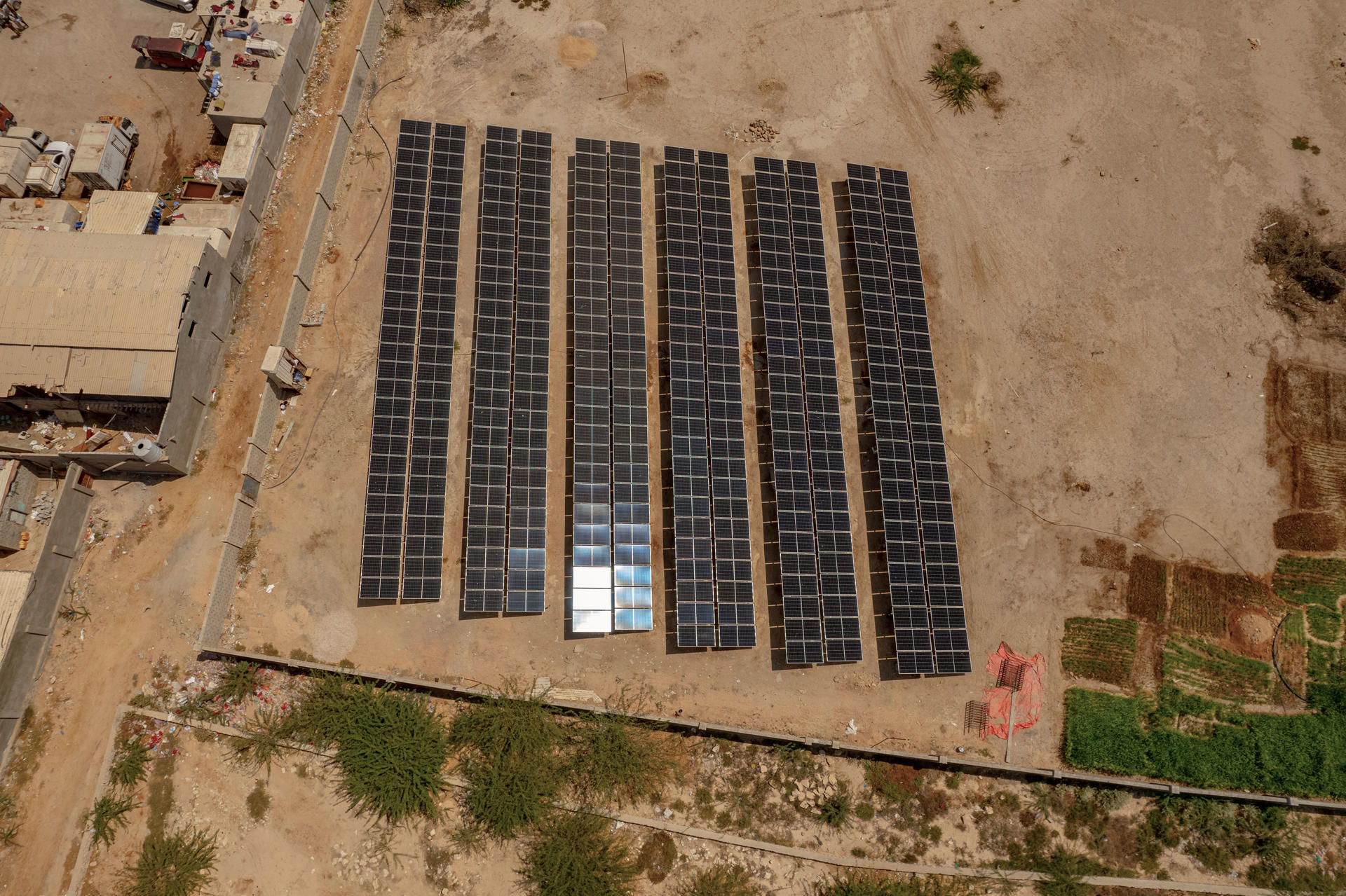 Aerial view of a solar panel installation in a dry, barren landscape.