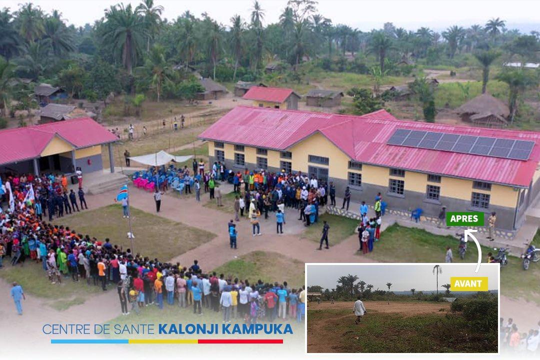Aerial view of a health center with a crowd gathered outside in a rural setting.