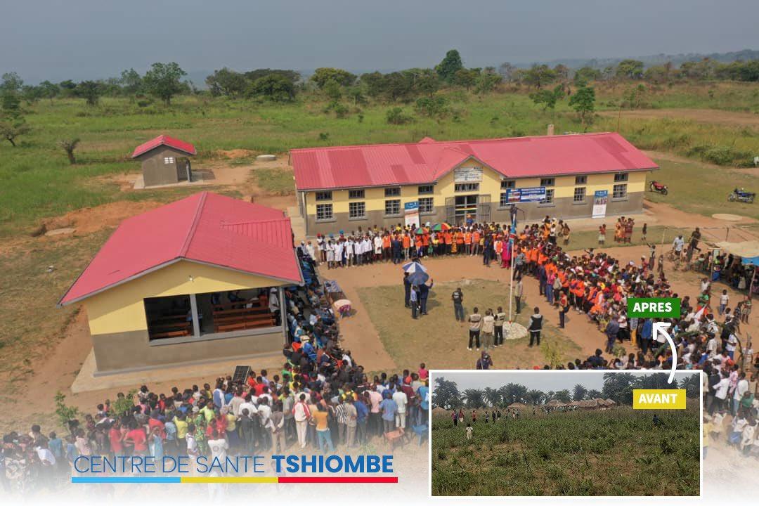 Aerial view of a gathering in front of a school building with a crowd in an open field.