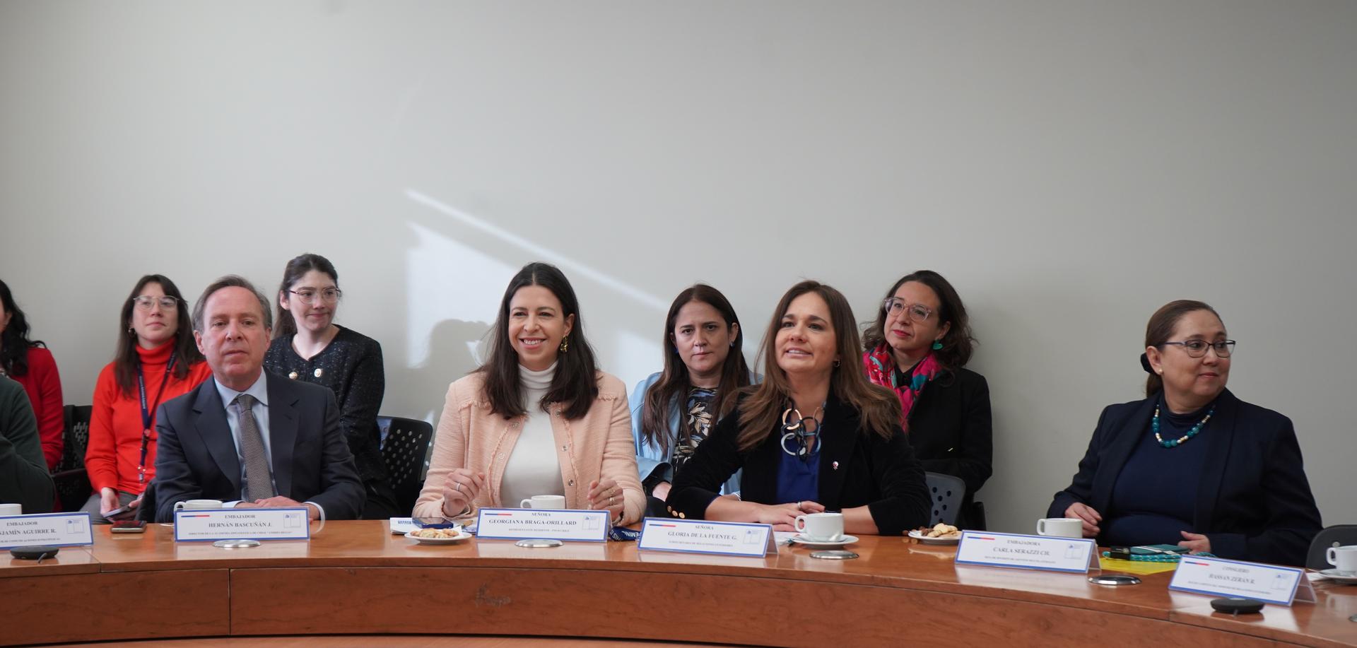 A diverse group of people sitting around a conference table, engaged in discussion.