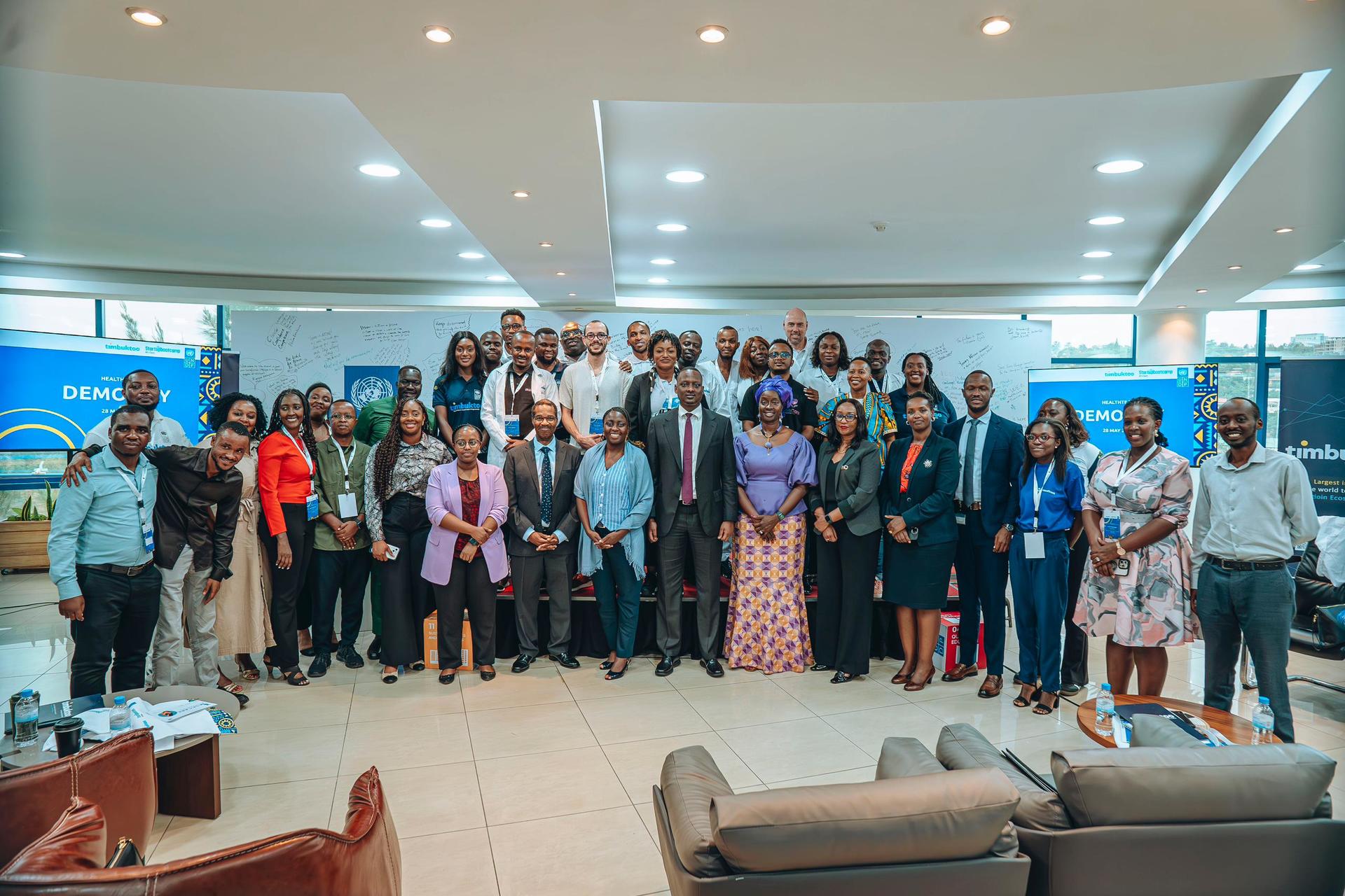 A large group of diverse professionals posing together in a modern office setting.