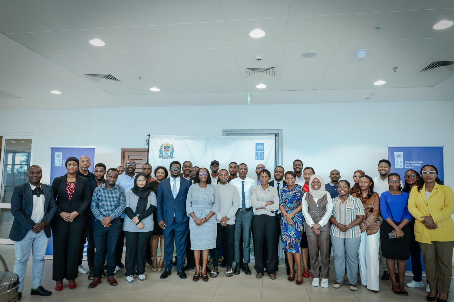 A diverse group of professionals posing together in a modern office setting.