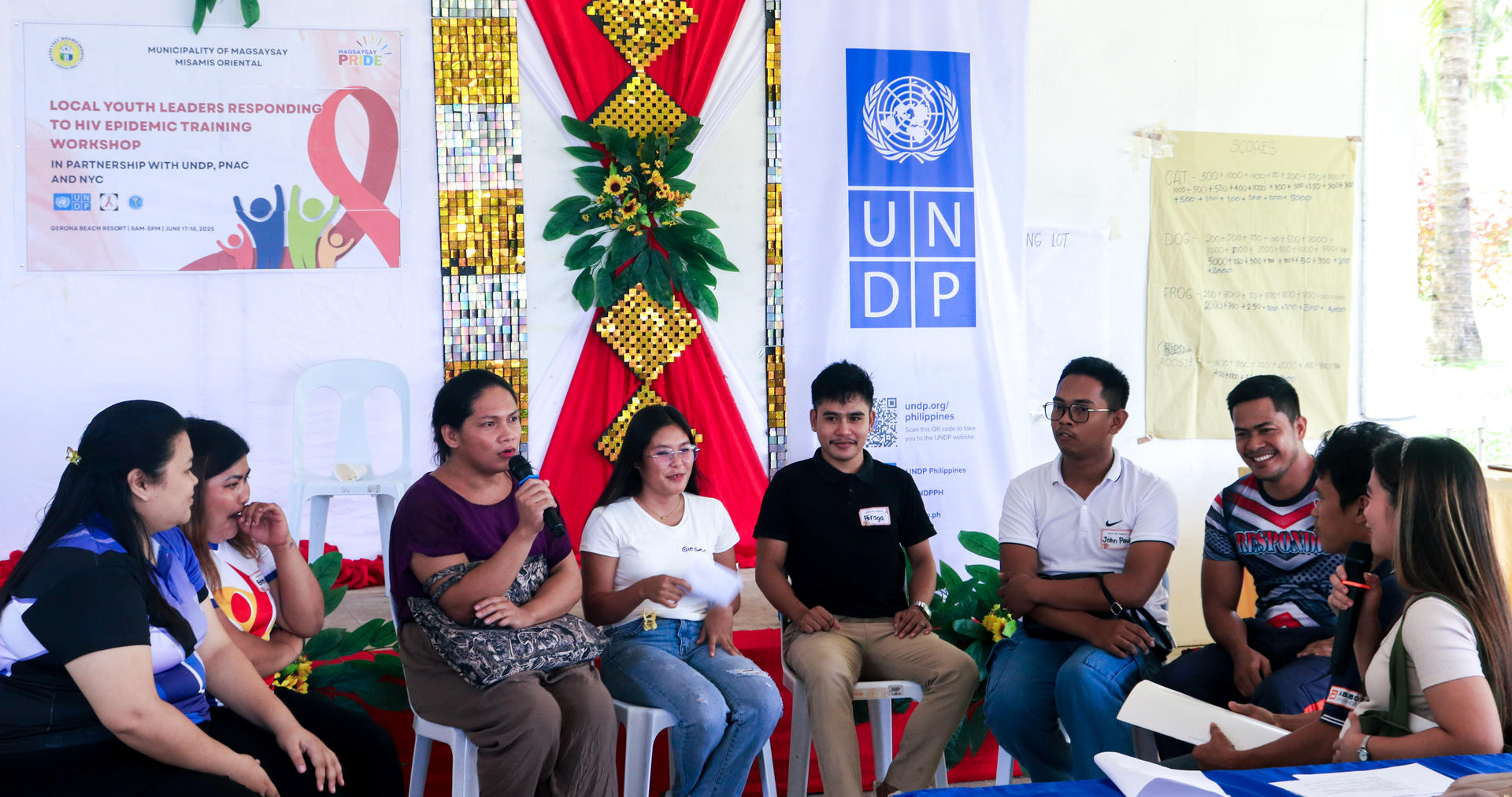 A group discussion in a bright room with diverse participants seated in a circle, engaged and focused.