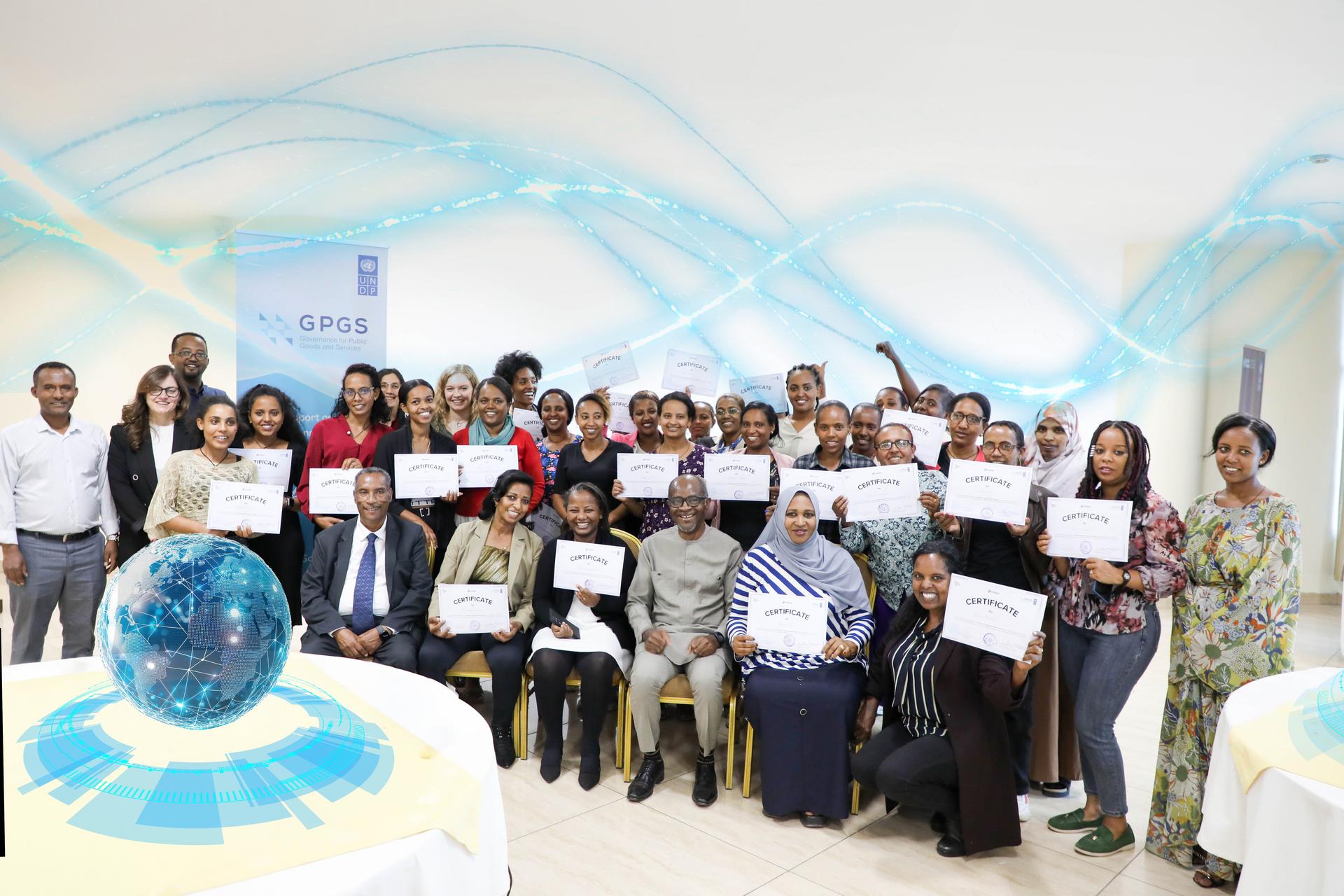A diverse group of people holding certificates, standing in a bright, modern setting.