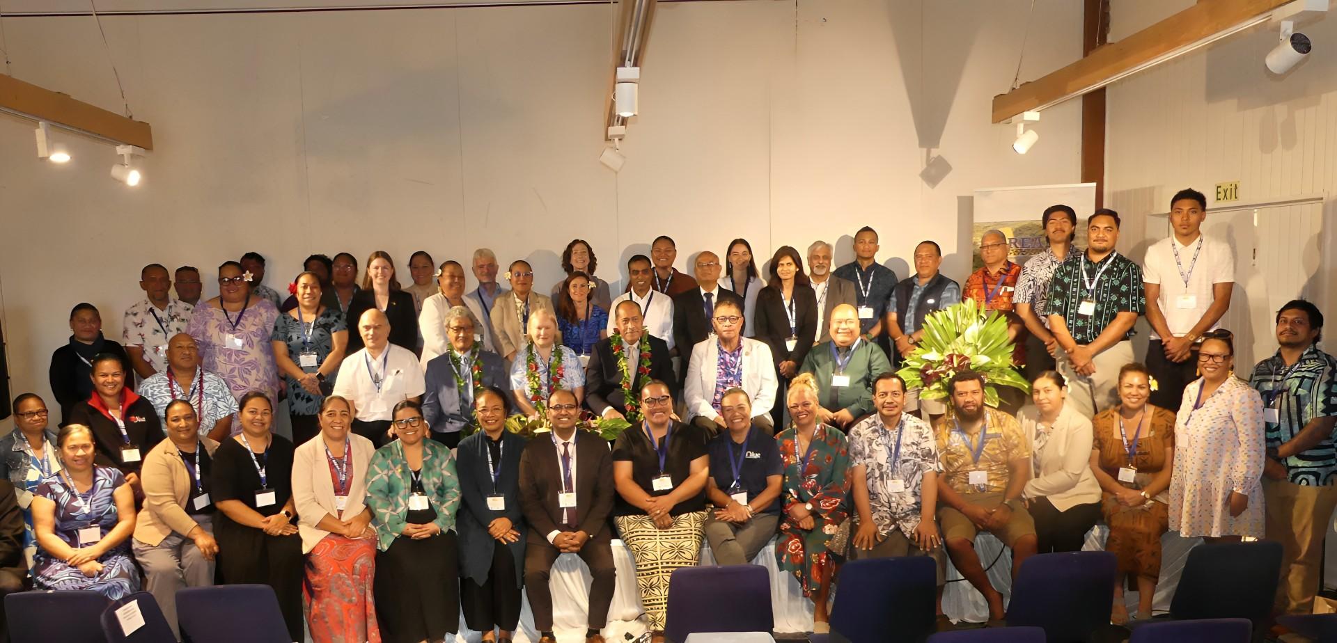 Group photo of diverse individuals standing together in a bright indoor setting in Niue.