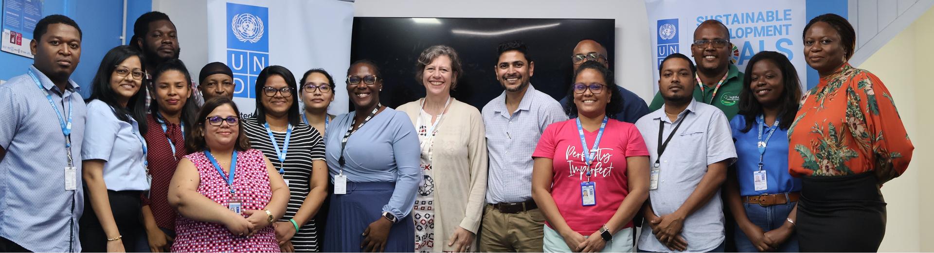 A diverse group of professionals posing together in a conference room, smiling.