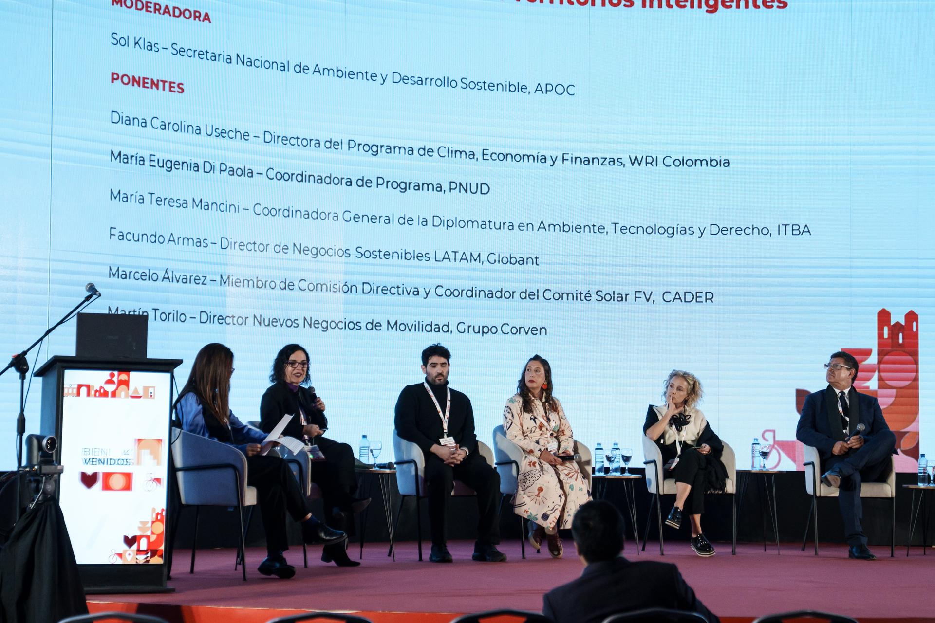 Un panel de discusión con seis expositores sentados en el escenario.