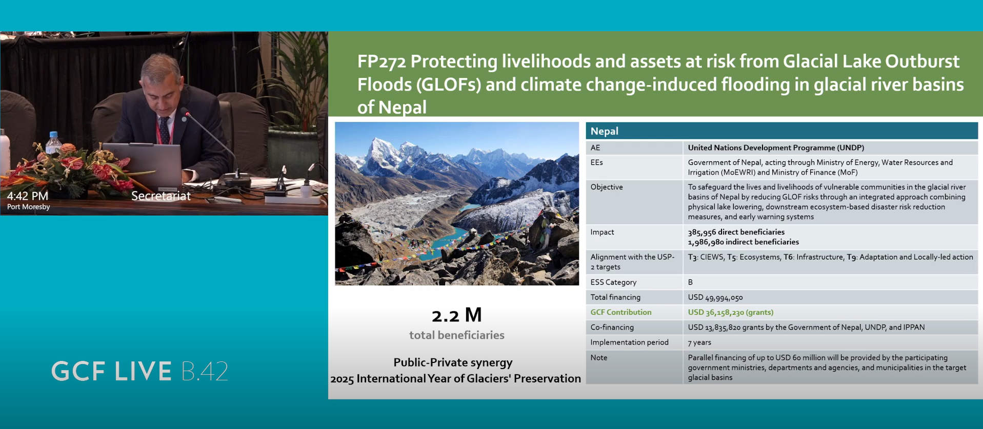 Person sitting at a table with documents, surrounded by a presentation on climate change.