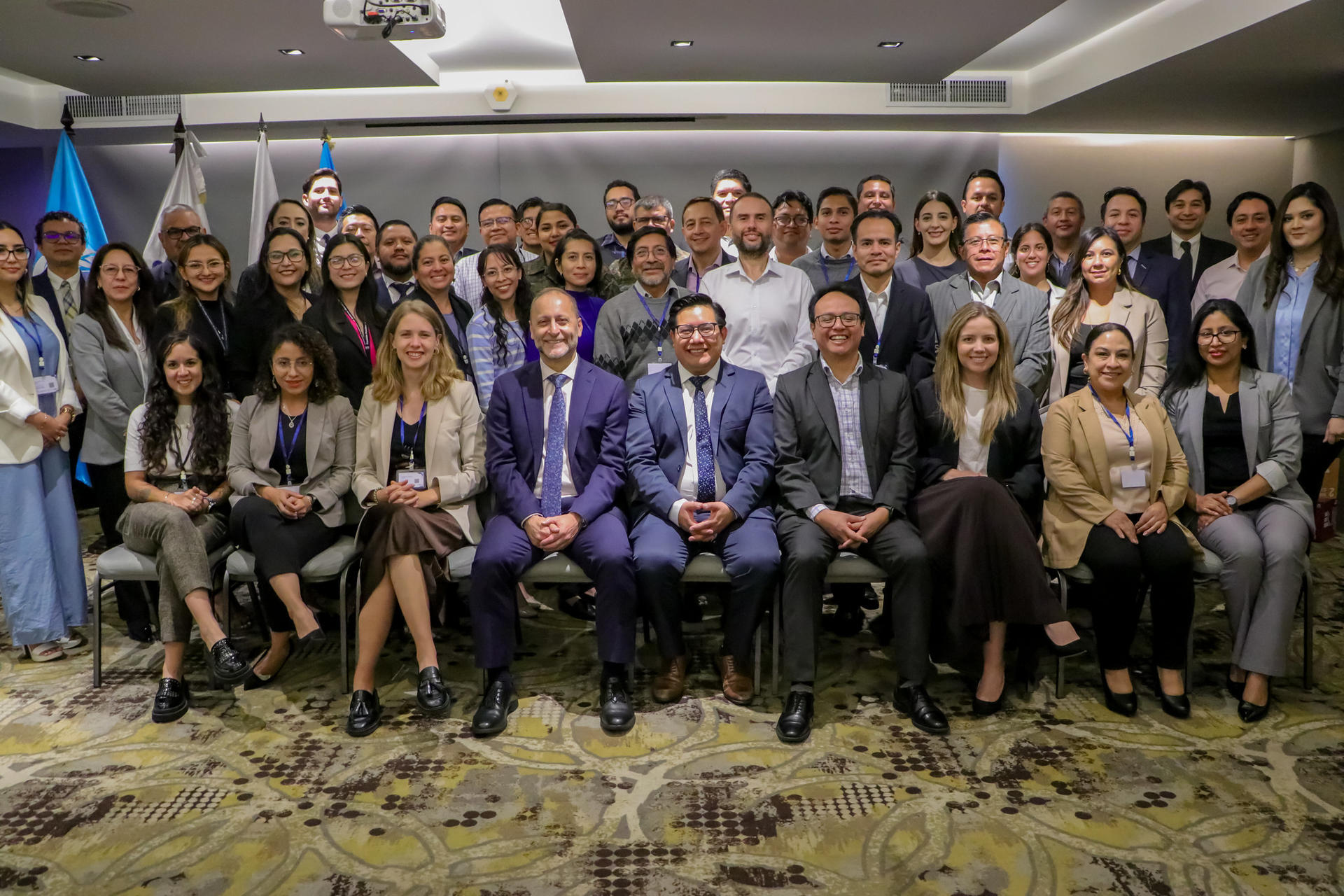 Group photo of diverse professionals posing together in a conference setting.
