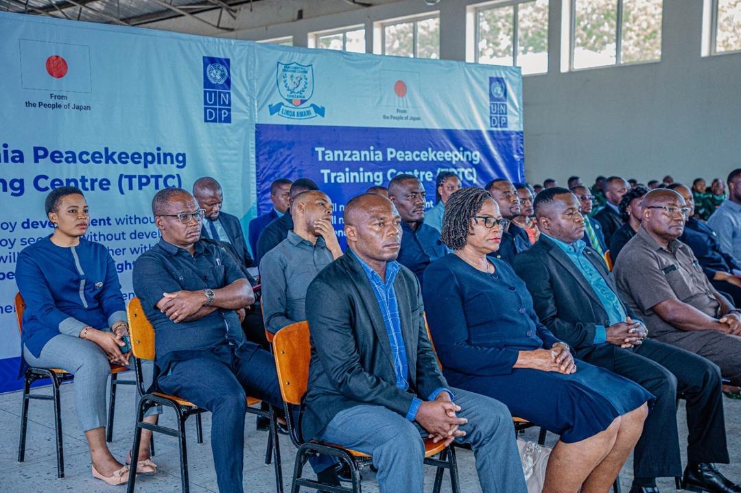 A diverse group of people seated in an indoor venue, focused on a presentation.