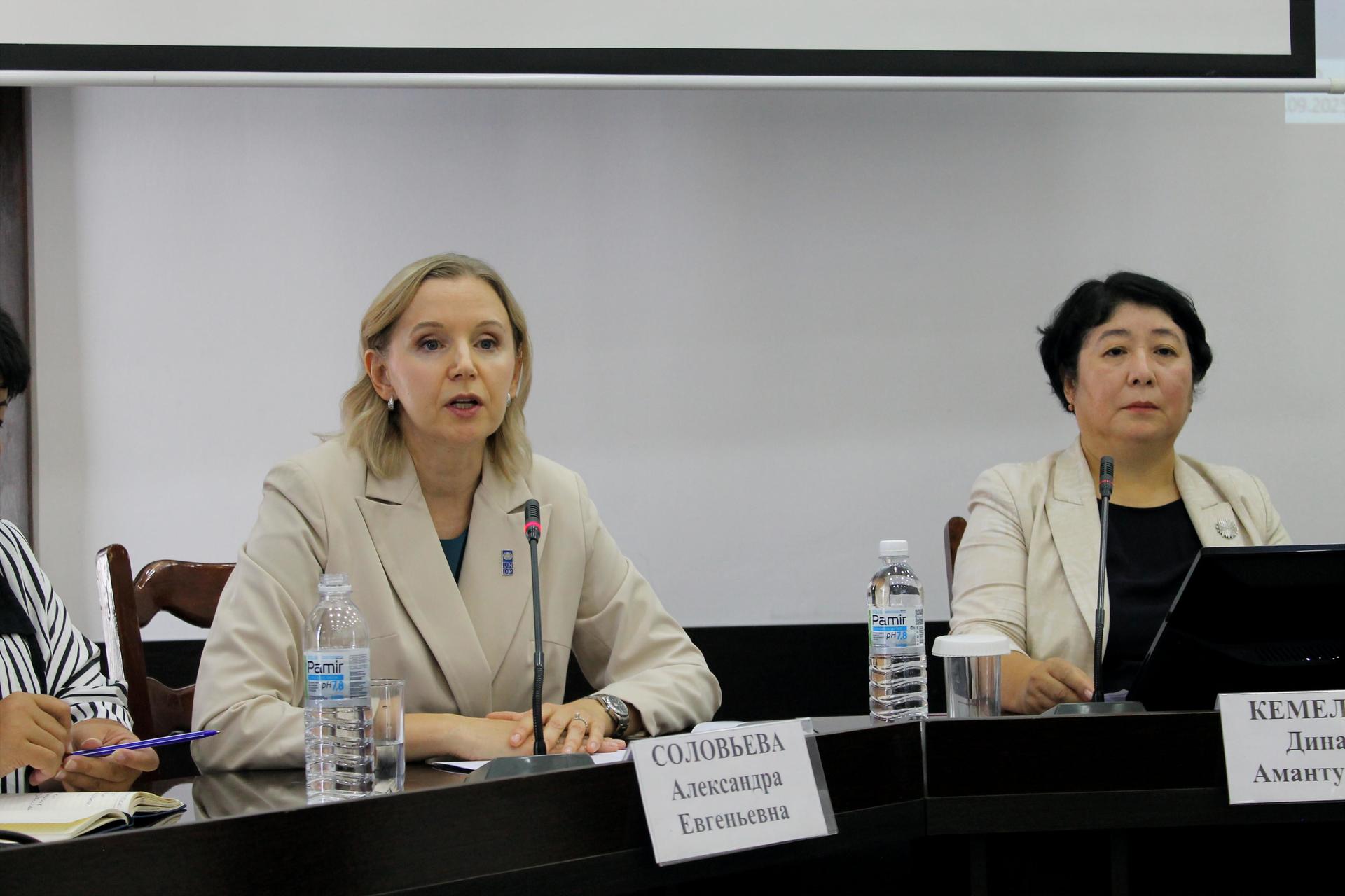 Two ladies are sitting at the table in the white jackets