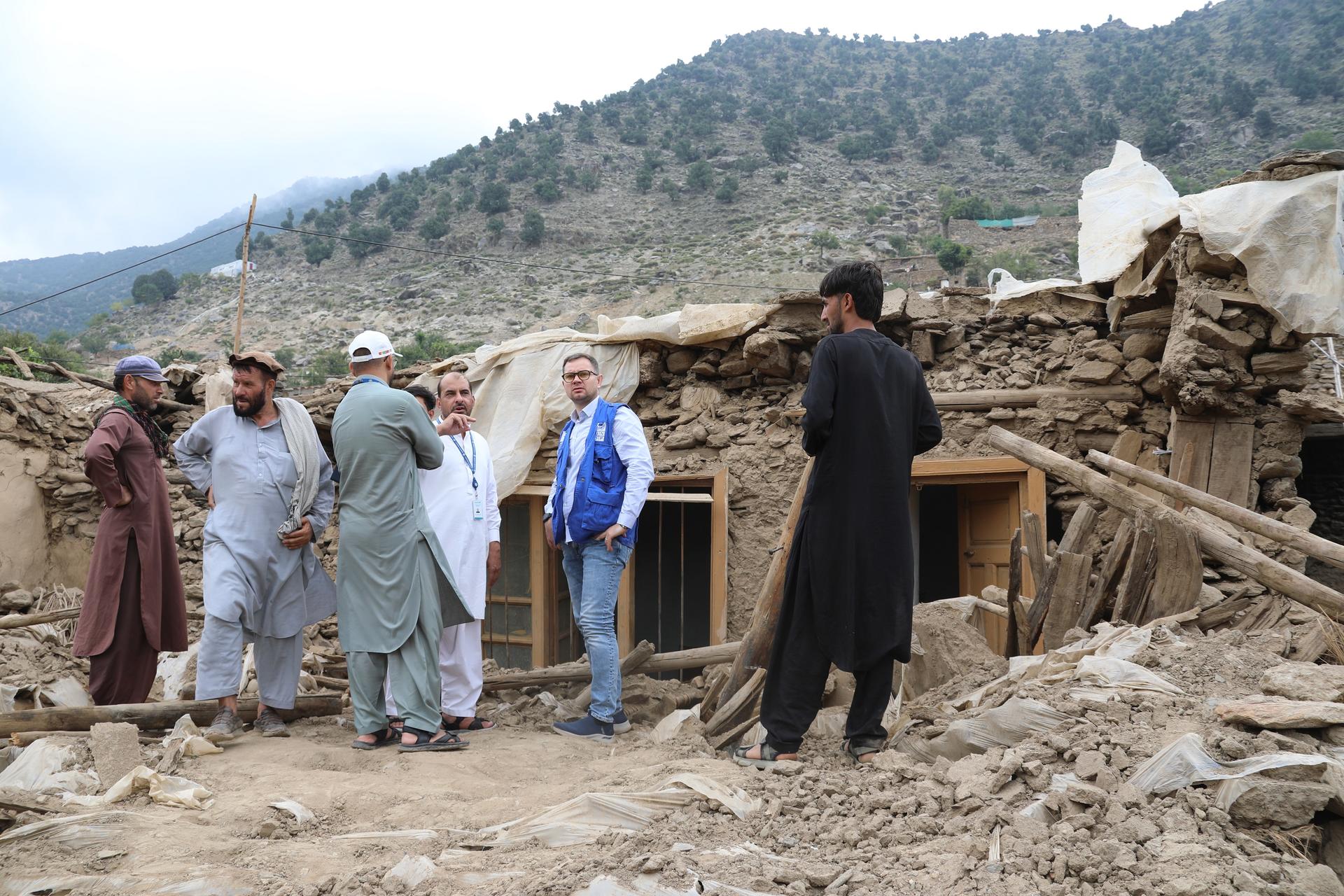Man talking in front of a destroyed home