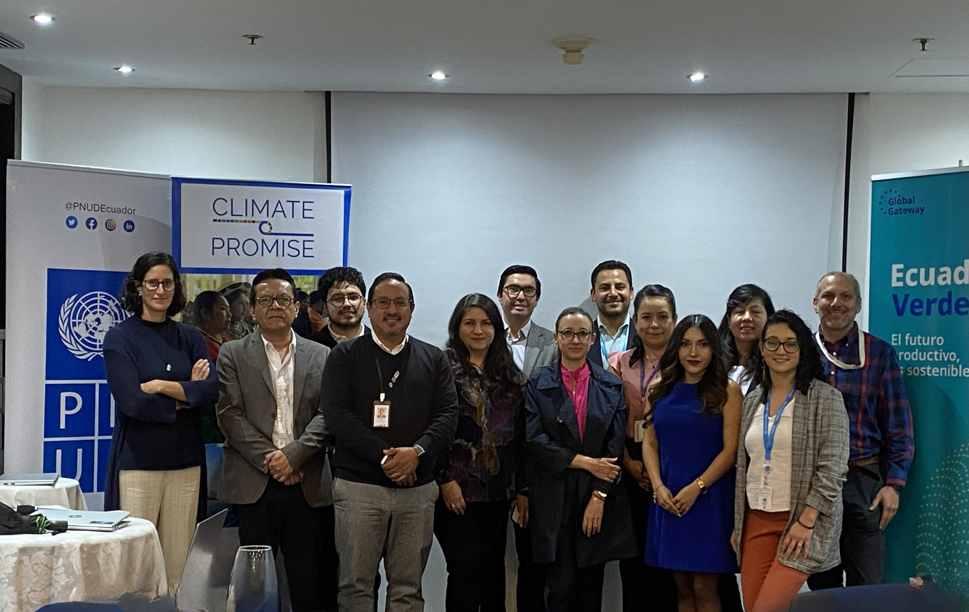 Diverse group posing at a climate conference, banners visible in the background.