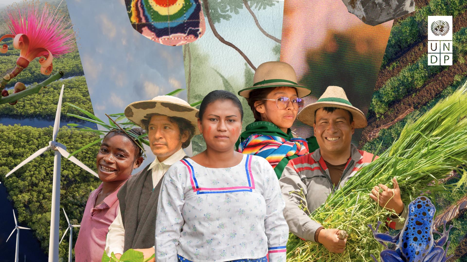 Group of people in hats pose at a colorful outdoor festival with banners and greenery.
