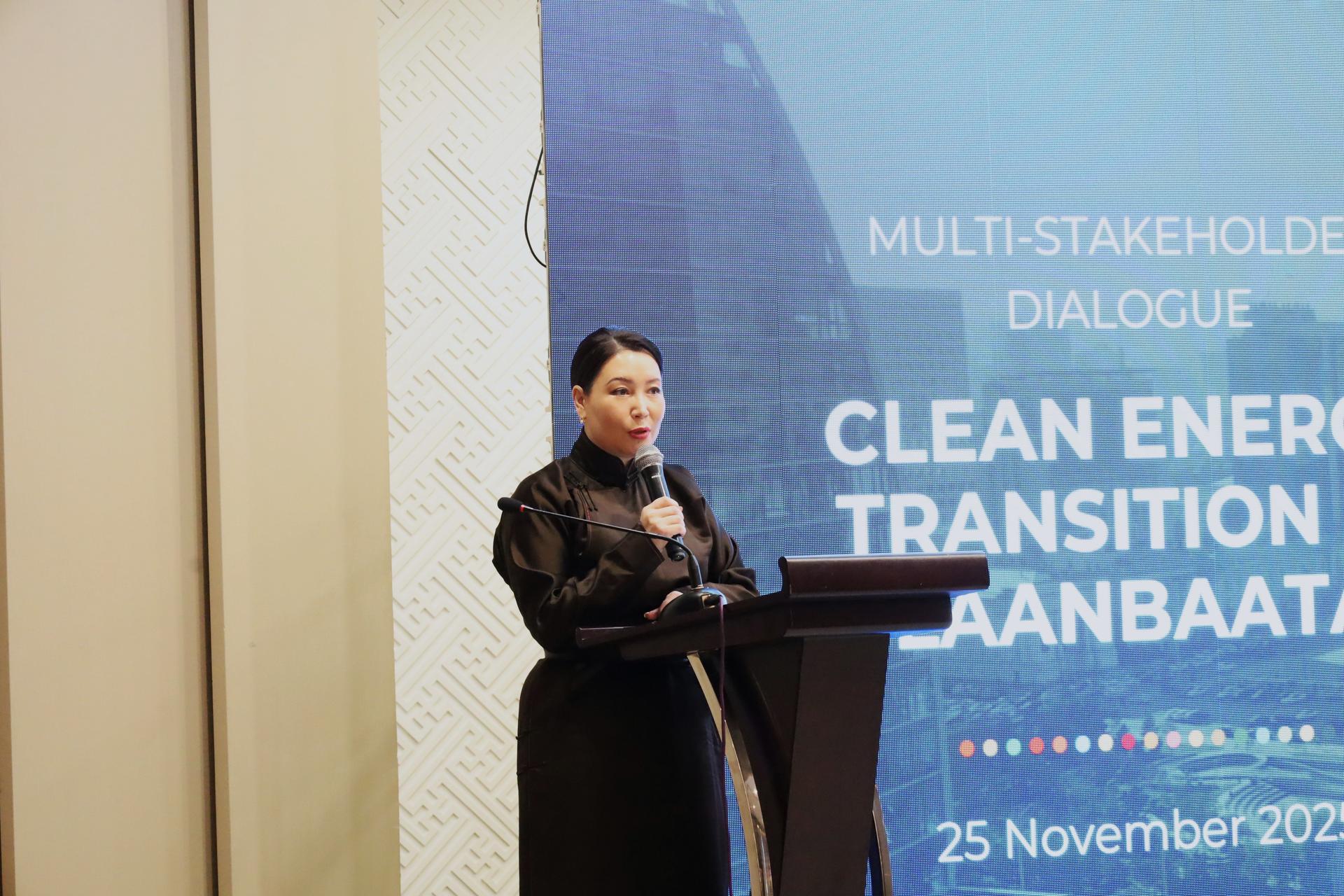Female speaker at a podium delivering a talk at a conference with a blue backdrop.