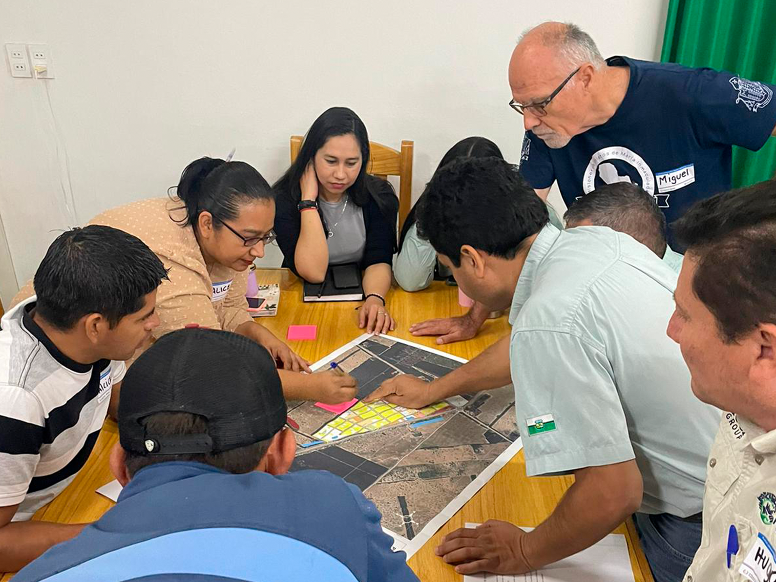 Group of people gathered around a table playing a board game.