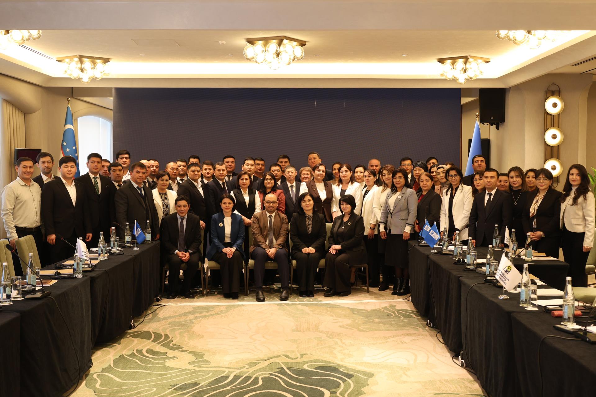 Large group of professionals in a conference room posing for a formal group photo.