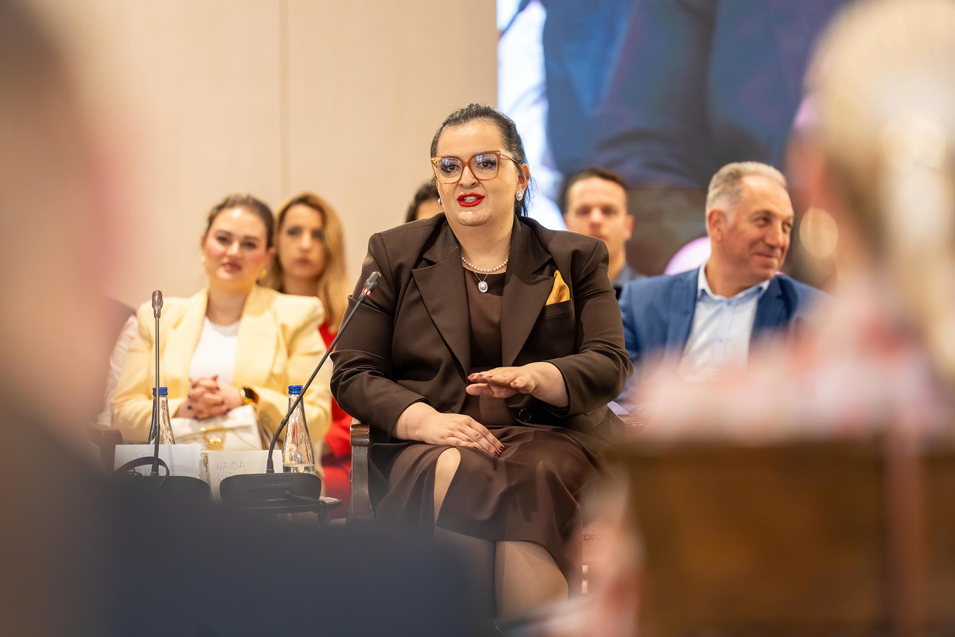 Group of professionals at a conference table, central figure in a dark suit.
