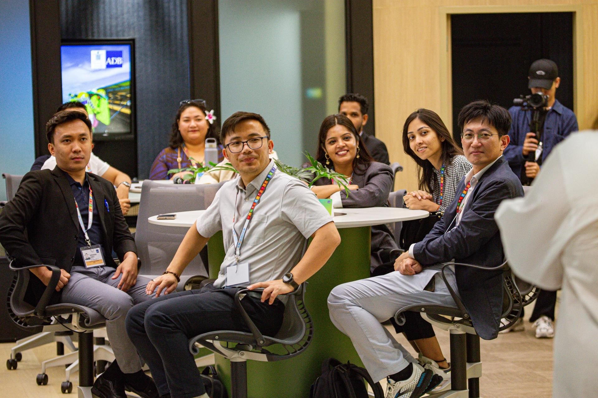 Group photo of colleagues in a modern classroom, smiling at the camera during a workshop.