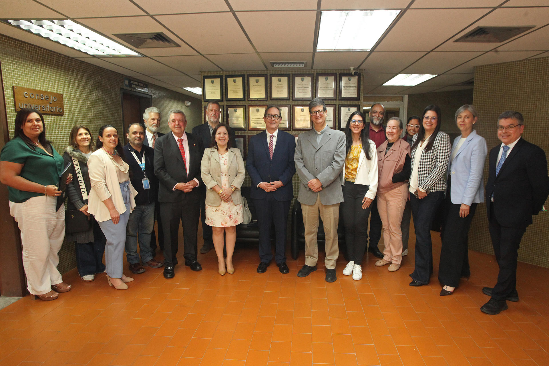 Group of professionals in business attire posing for a photo in a conference room.
