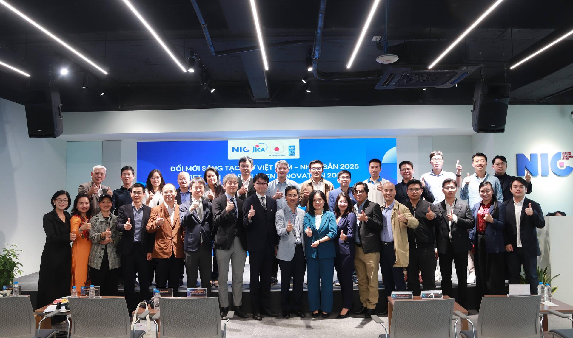 Group of diverse attendees posing on a conference stage under a blue banner.