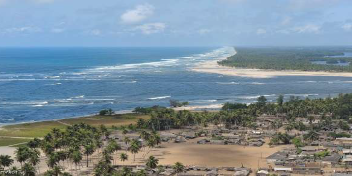 Coastal landscape with a crescent beach, blue sea, and sparse dune vegetation.