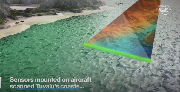 Aerial view of turquoise coast and beach, with a multicolored triangular sensor on an aircraft.
