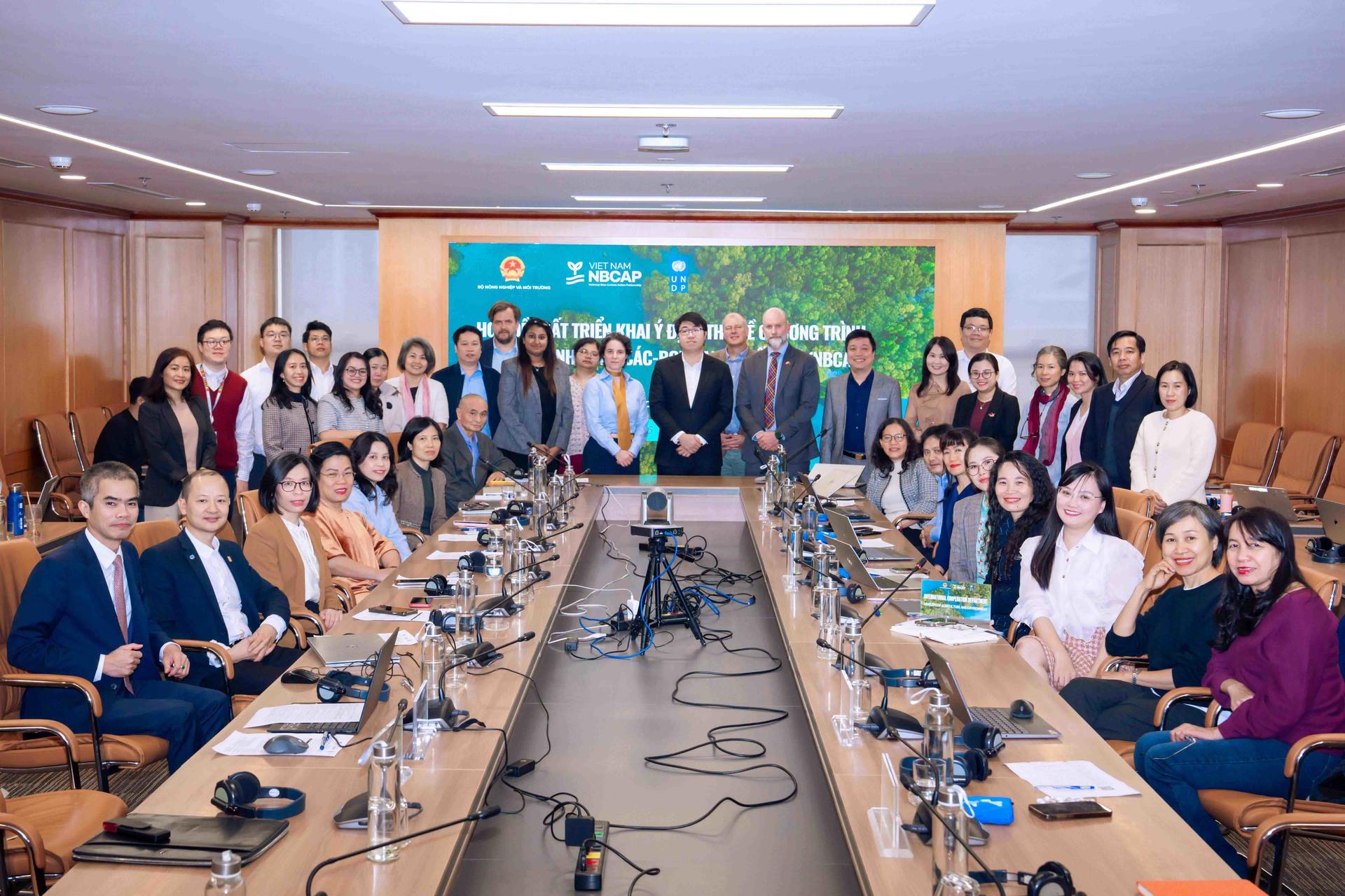 Group photo of professionals around a long conference table in a boardroom.