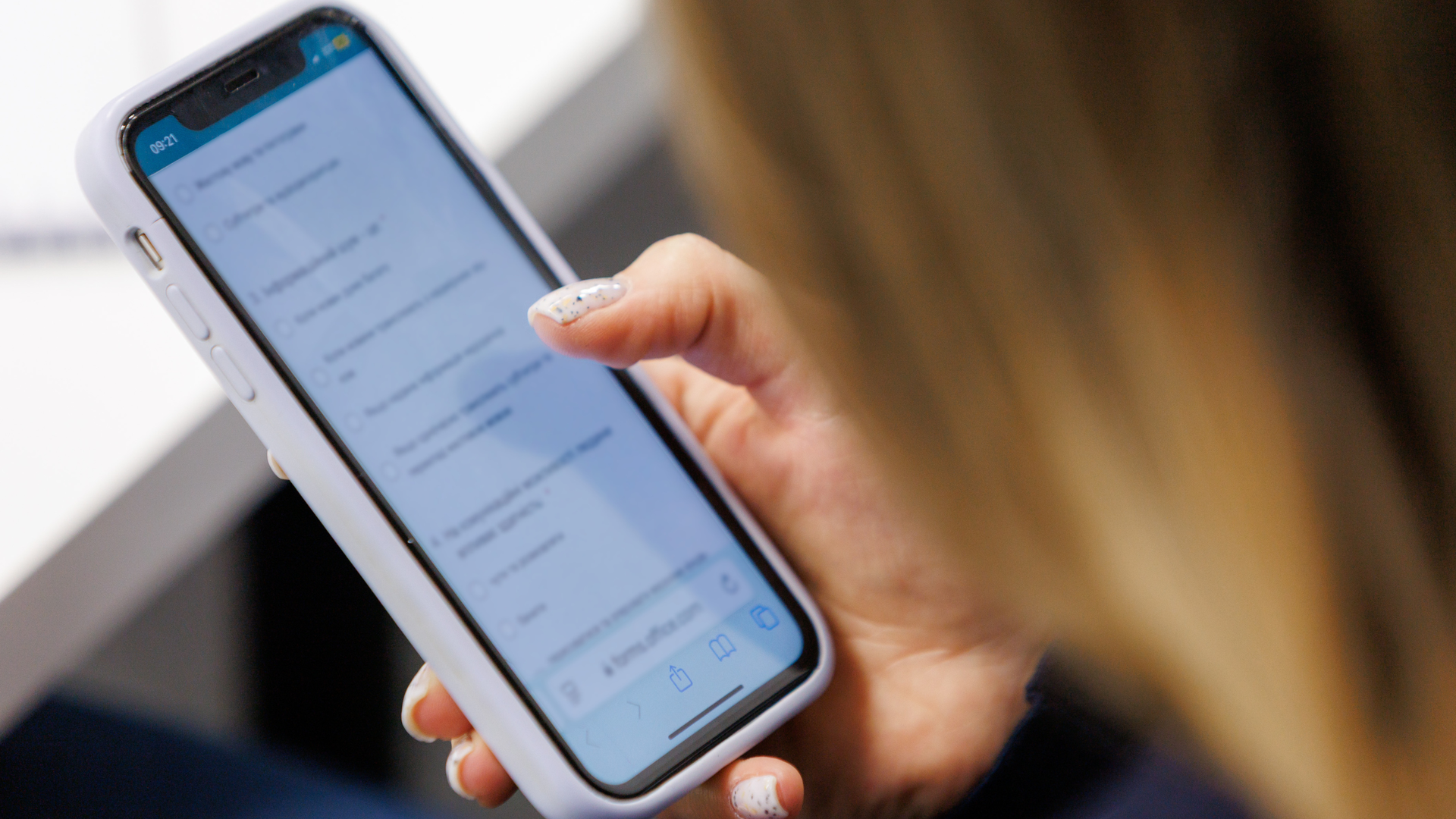 Close-up of a person holding a smartphone displaying a messaging app.