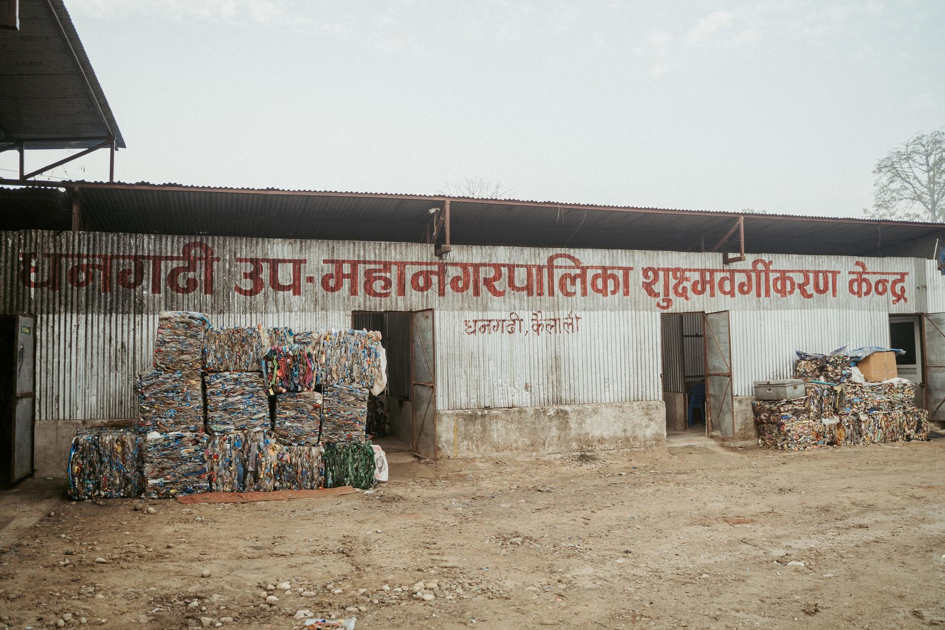 Front view of a micro segregation centre; pallets and bundles stacked outside.