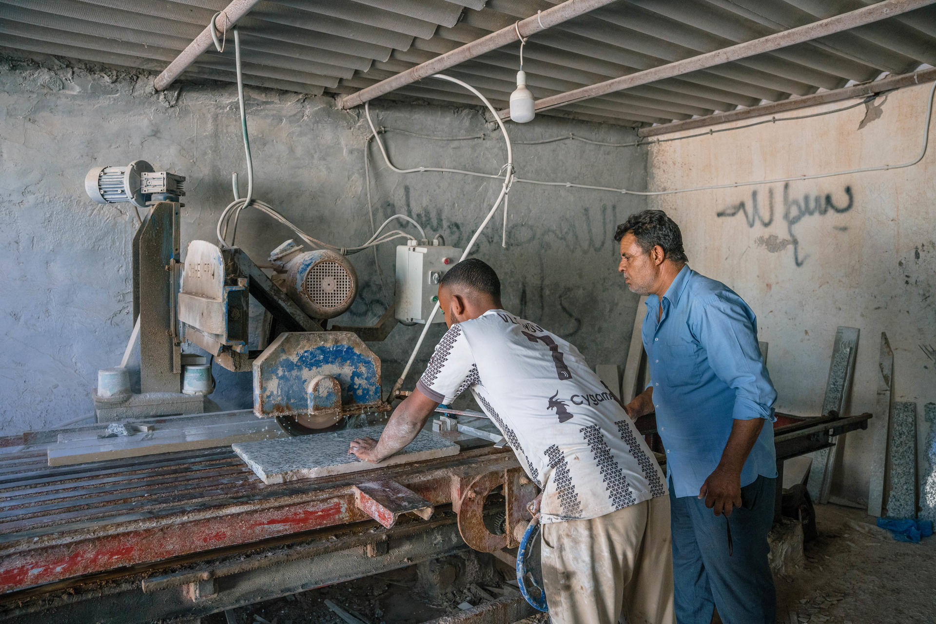 Mabrouk dans son atelier de marbre entrain de vérifier le travail de son collégue