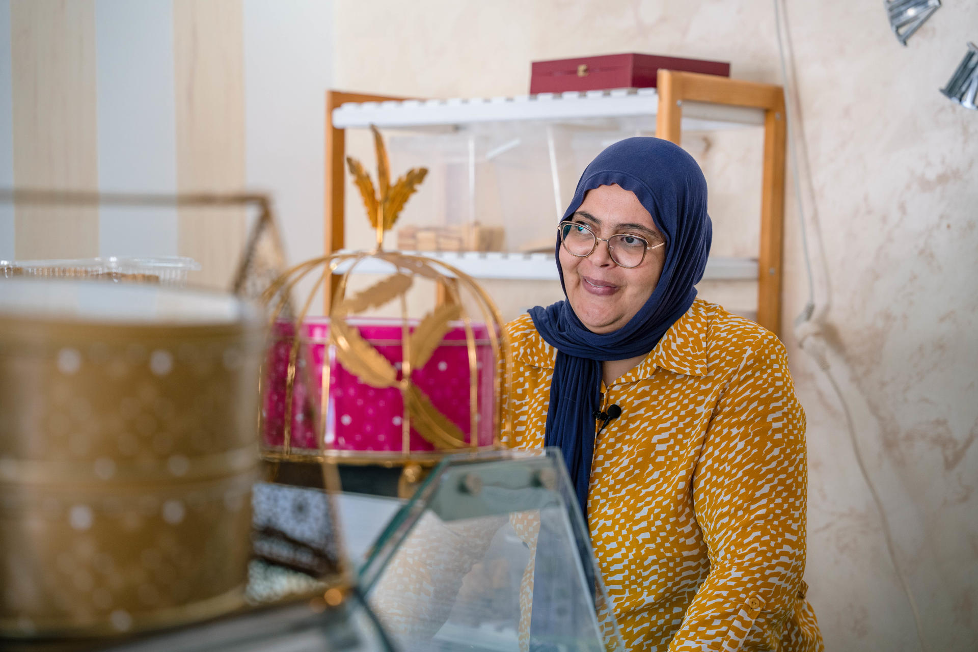 Nabiha dernière le comptoir de sa patisserie 