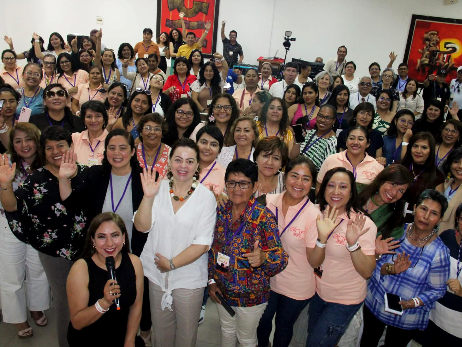 Group photo of a large, diverse crowd smiling in a bright room.