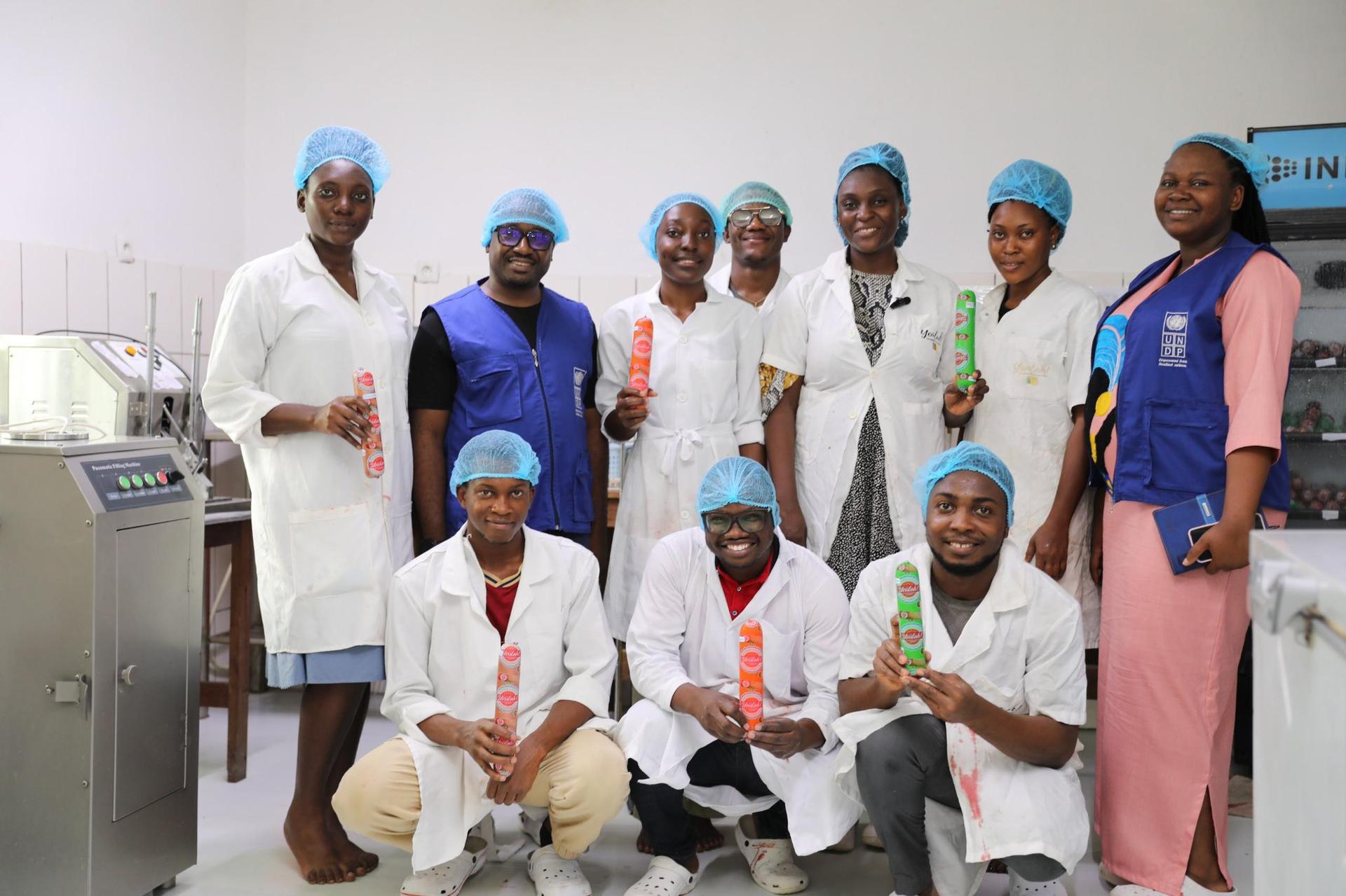 Group of healthcare workers wearing blue surgical caps posing for a photo in a clinic.