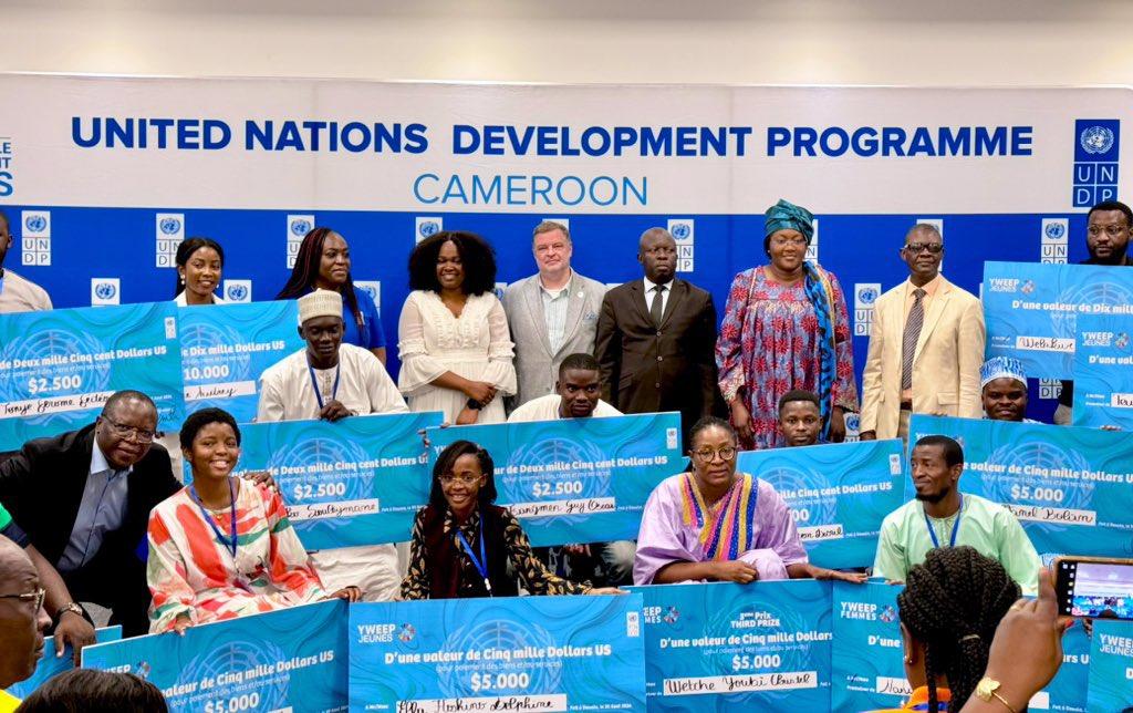 Photograph of a diverse group at a UNDP Cameroon event with blue banners.
