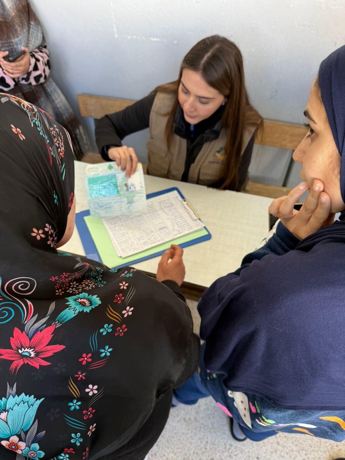 Three women sit around a table studying with notebooks and a colorful folder.
