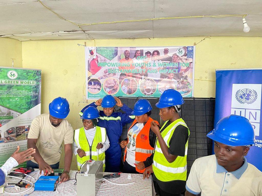 Group of people in hard hats and safety vests at a construction training booth.
