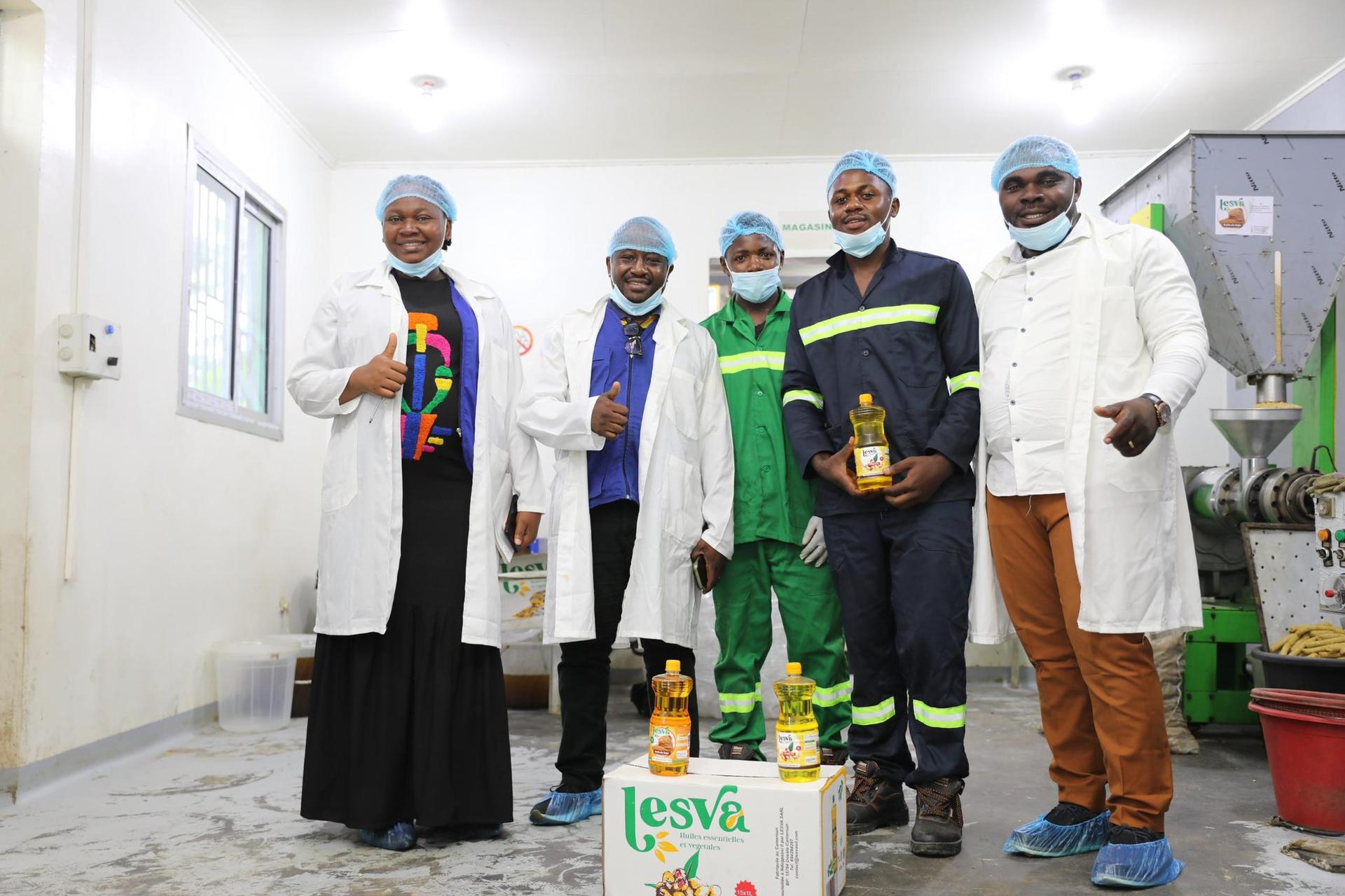 Group of healthcare workers in PPE posing in a hospital hallway with a cardboard box in front.
