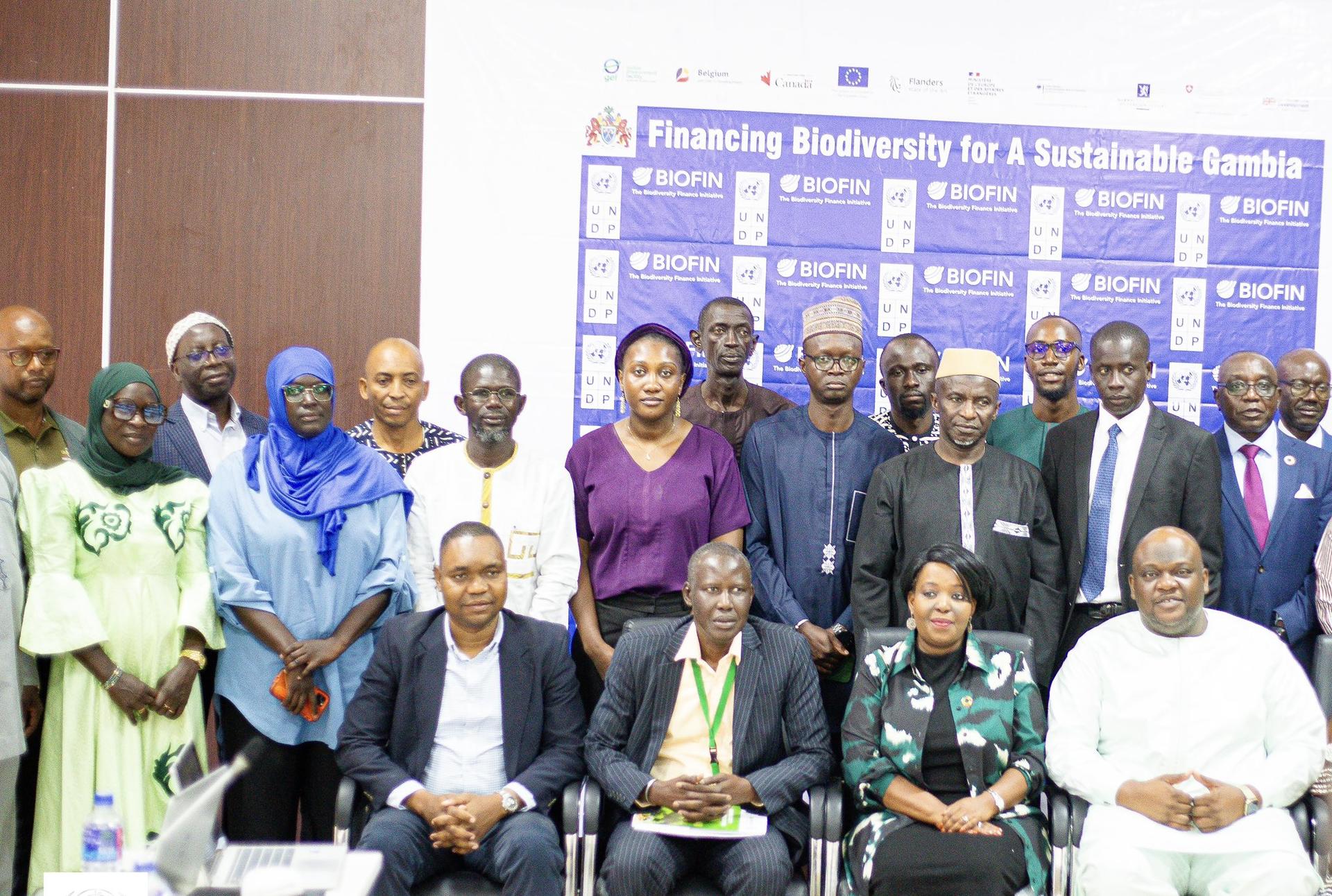Group of diverse professionals posing for a conference photo in front of a blue banner.