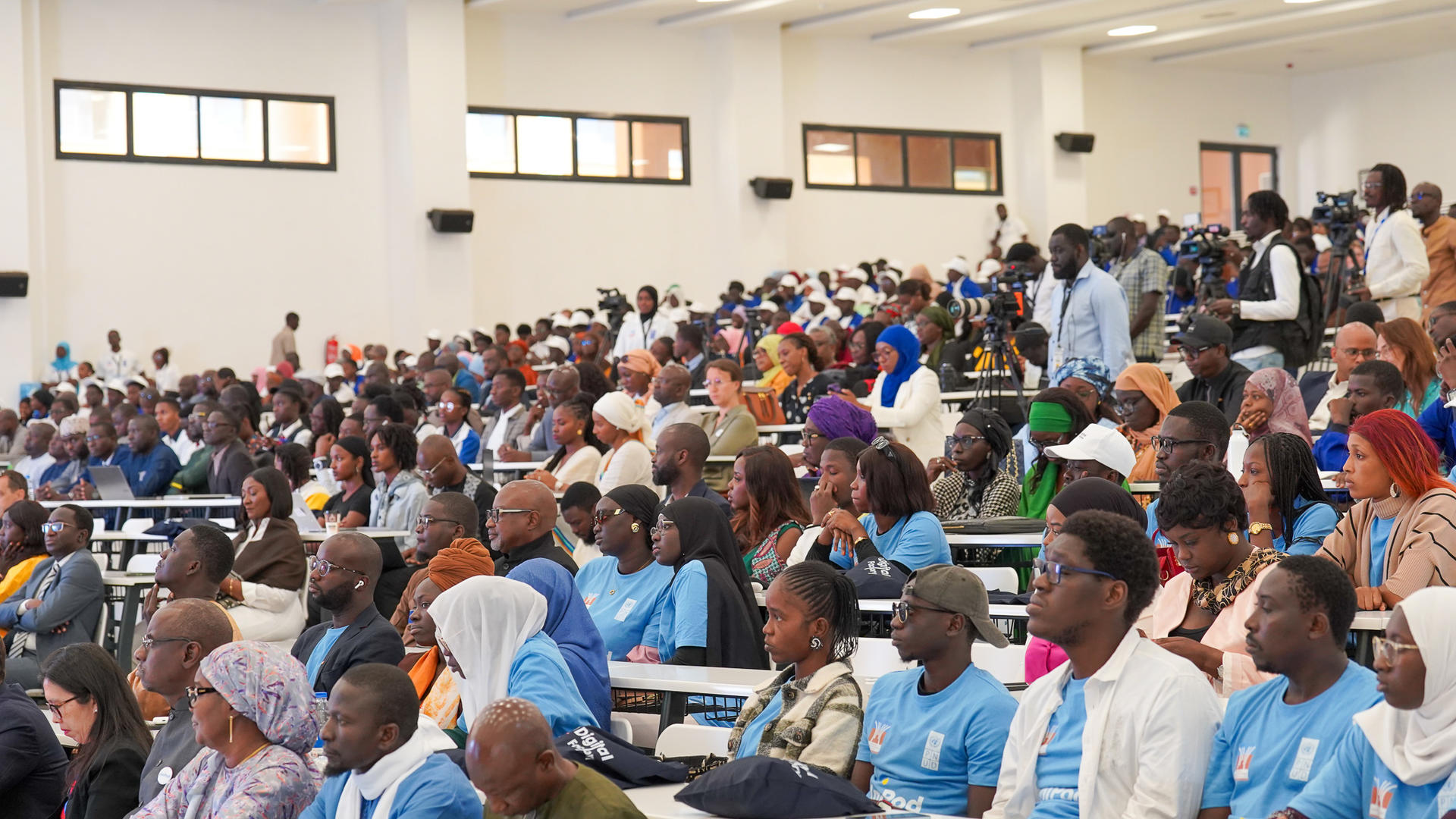 Une salle comble, remplie de participants à une conférence.
