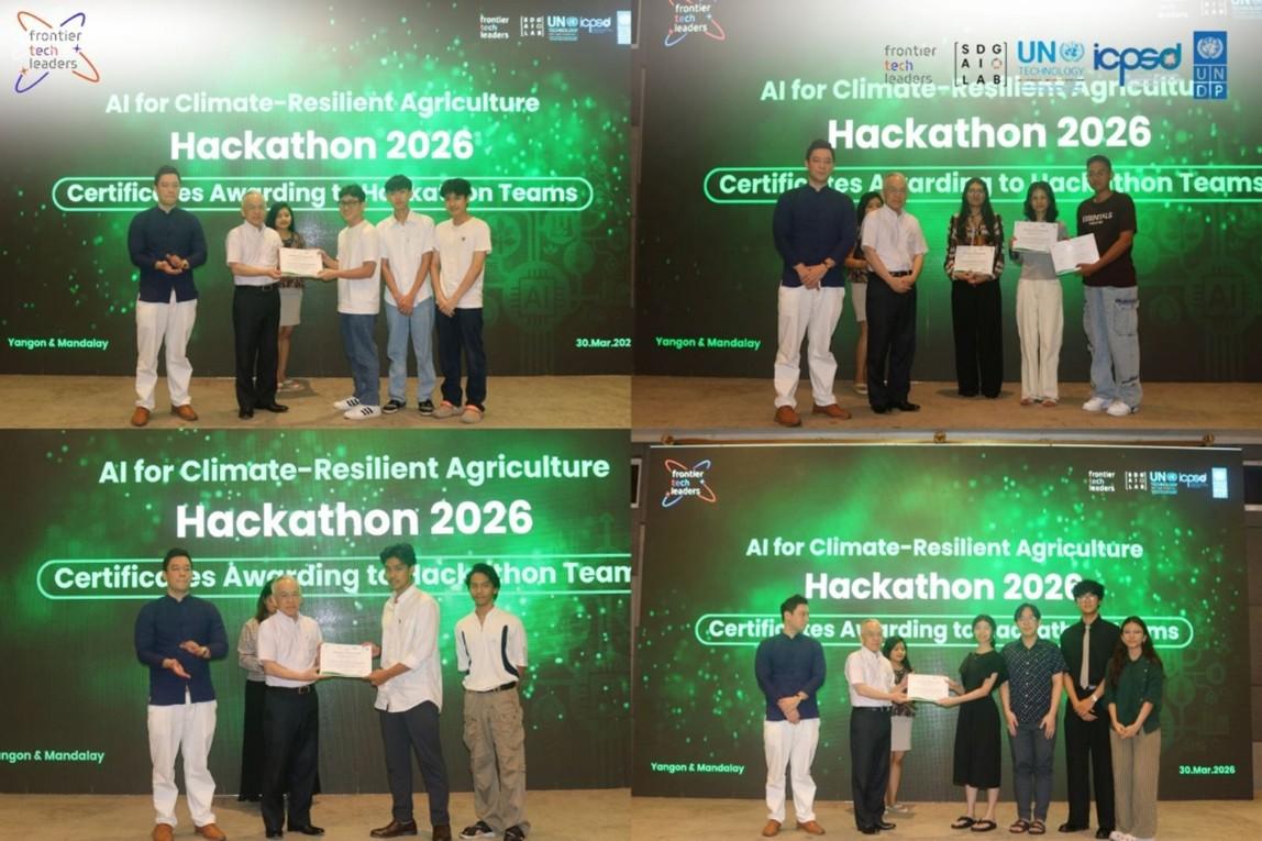 People on stage posing with certificates at Hackathon 2026, green backdrop.