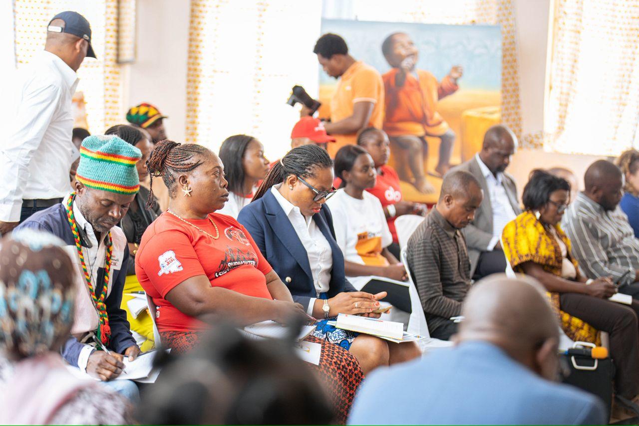 Photograph of diverse attendees seated in a bright room at a community workshop.