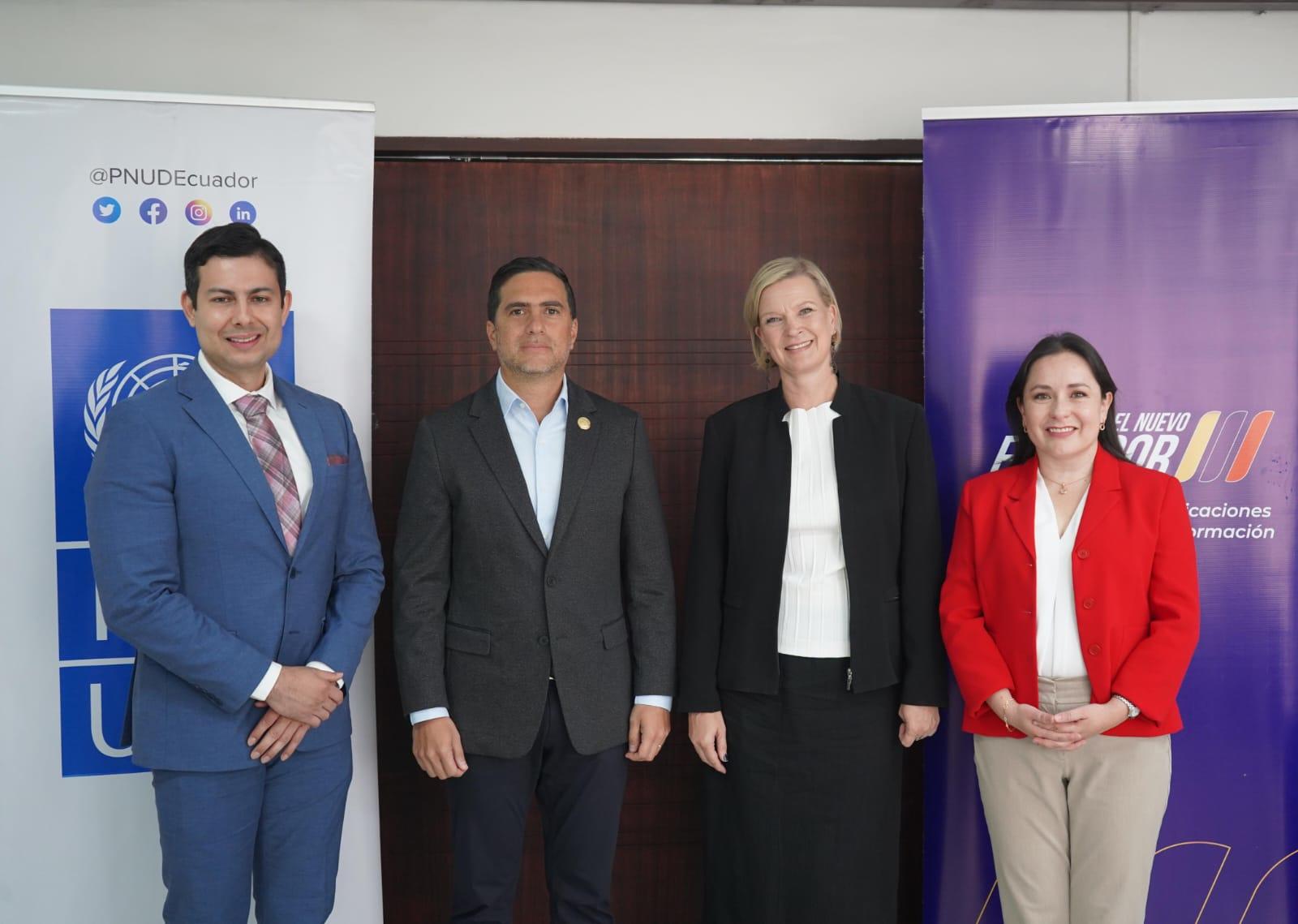 Group photograph of four professionals posing in front of blue and purple banners.
