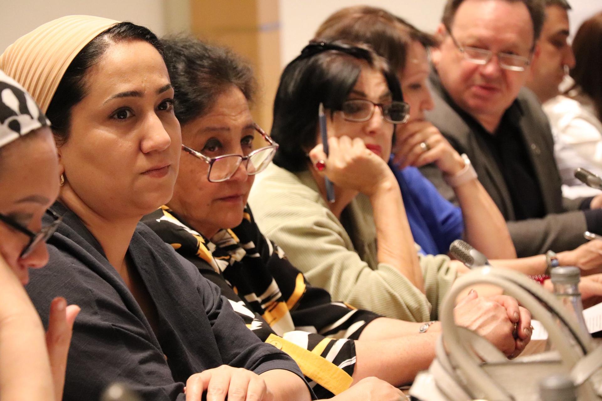 Photo: Seated audience at a conference, faces blurred, diverse clothing.