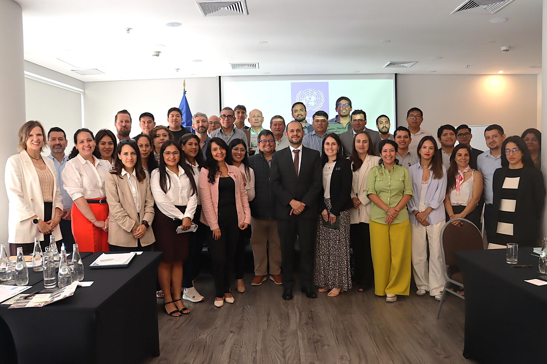 Large group of professionals posing for a group photo in a conference room.