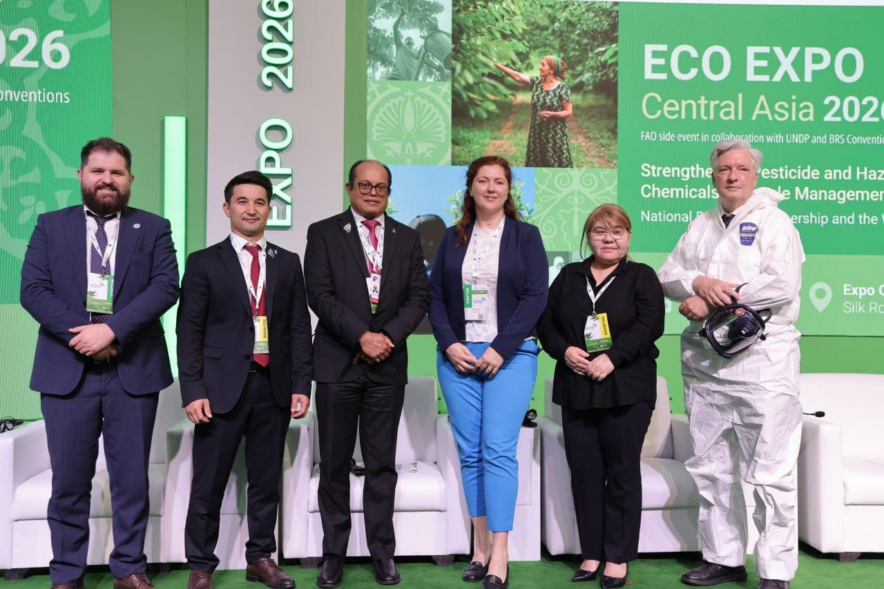 Six people in formal attire pose on a stage with green Eco Expo Central Asia 2022 banners.