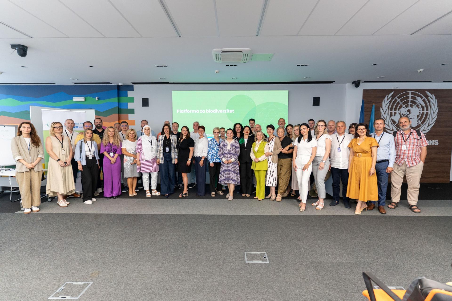 Group photo of diverse professionals posing in a conference room.