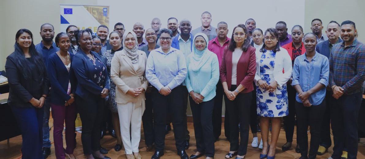 Diverse group of professionals posing for a group photo in a conference room.